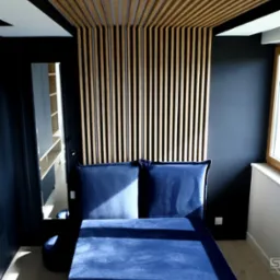 Nowoczesna sypialnia z ciemnymi ścianami, drewnianym panelem dekoracyjnym na ścianie i suficie oraz niebieskim tapicerowanym łóżkiem z zagłówkiem.