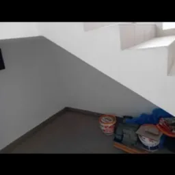 Wykończenie schodów z farbą i narzędziami w Twardogórze. Widok z dołu, ukazujący detale malowania i potrzebne akcesoria.