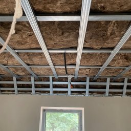 Konrad Sobol - Montaż metalowej konstrukcji sufitu podwieszanego z izolacją z wełny mineralnej, widok na okno i ścianę