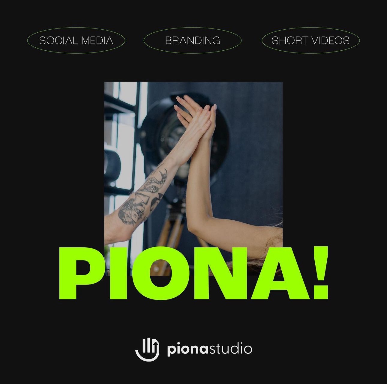 Dwie ręce w geście przybijania piątki na tle studia z oświetleniem, z napisem 'PIONA!' w jaskrawej zieleni i logo 'pionastudio' poniżej. Jedna ręka ma tatuaż.
