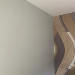 Ściana pomalowana na szaro sąsiaduje z dekoracyjną ścianą z paneli w odcieniach brązu i beżu, tworząc geometryczny wzór z zaokrąglonymi kształtami. Widoczny kontakt elektryczny.