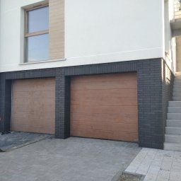 Usługi remontowo budowlane Mykola Dmytryk - Dwa brązowe garaże segmentowe z czarną cegłą elewacyjną, widok z zewnątrz, betonowe schody obok.