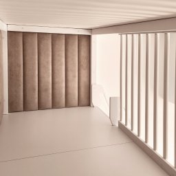 EXPO Kawałkowski Krzysztof - Białe schody z drewnianą balustradą i miękkim, pionowo żłobionym panelem ściennym w odcieniach beżu, tworzące minimalistyczną przestrzeń.