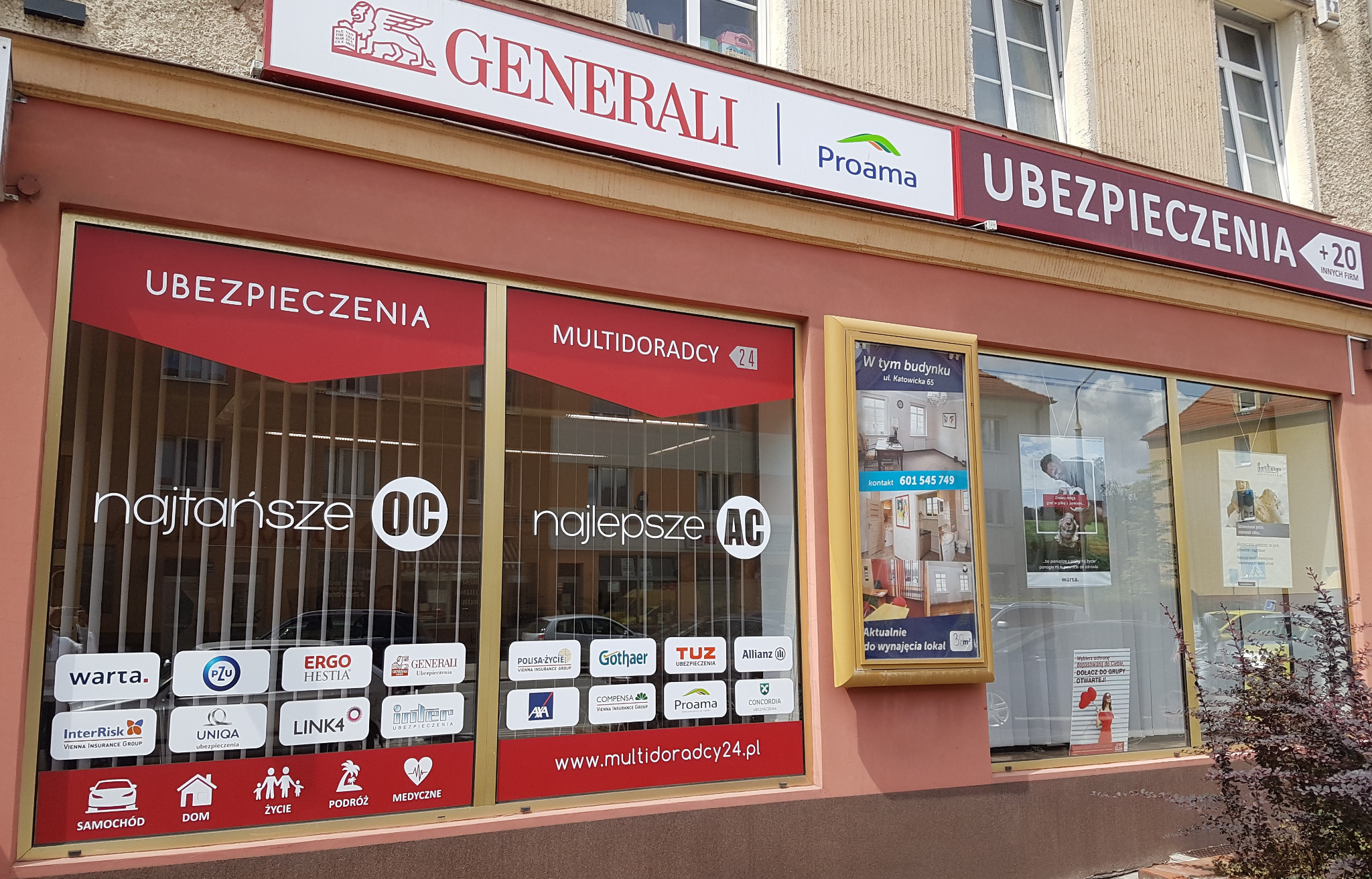 Fasada budynku z szyldami firm ubezpieczeniowych, w tym Generali i Proama, oraz informacją o multiagencji ubezpieczeniowej Multidoradcy24 z ofertą OC i AC.