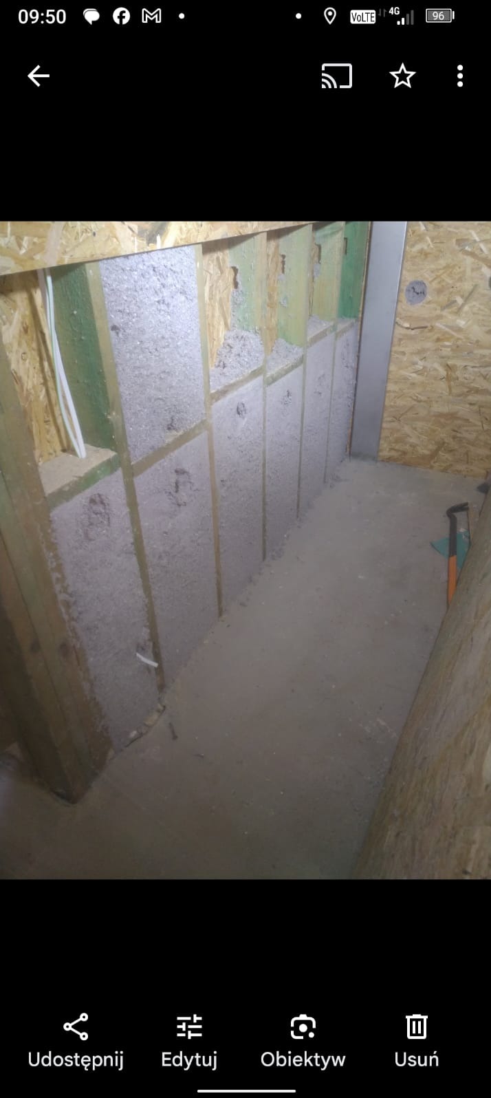 Wypełniona wełną mineralną konstrukcja szkieletowa ściany wewnętrznej z widocznymi przewodami elektrycznymi, przed zakryciem płytami OSB.