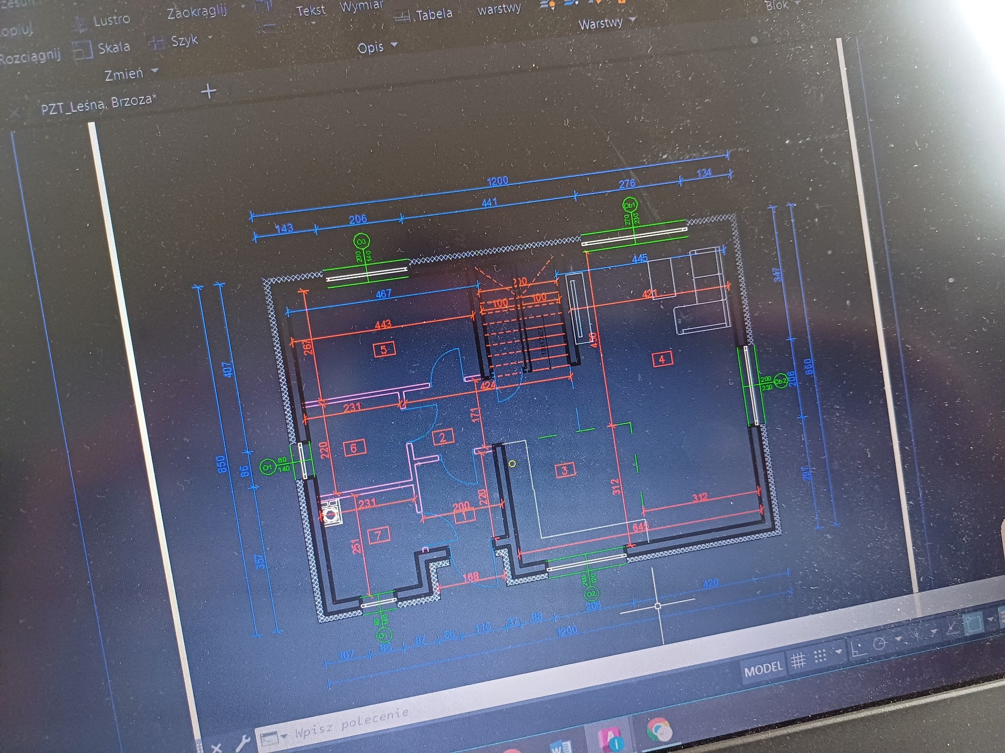Rzut poziomy domu jednorodzinnego z wymiarami, wyświetlony na ekranie laptopa w programie do projektowania CAD, z widocznymi narzędziami programu i nazwą pliku 'PZT_Leśna, Brzoza'.