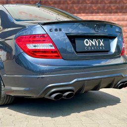 GHOST AUTODETAILING BIAŁYSTOK - Tył szarego samochodu Mercedes-Benz C 63 po nałożeniu powłoki ochronnej Onyx Coating, widoczne podwójne końcówki układu wydechowego, światła tylne LED i logo producenta.