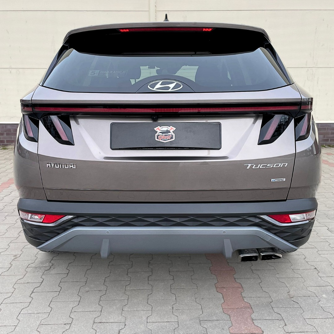 Tył szarego samochodu Hyundai Tucson po zabiegach detailingowych, widoczny naklejka z logo firmy na tablicy rejestracyjnej.