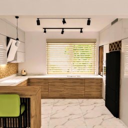 Katarzyna Zasadzińska Projekty Wnętrz - Jasna kuchnia z drewnianymi frontami szafek, marmurową podłogą i wyspą z zielonymi krzesłami barowymi, oświetlona reflektorami i wiszącymi lampami, widok na okno z żaluzjami.