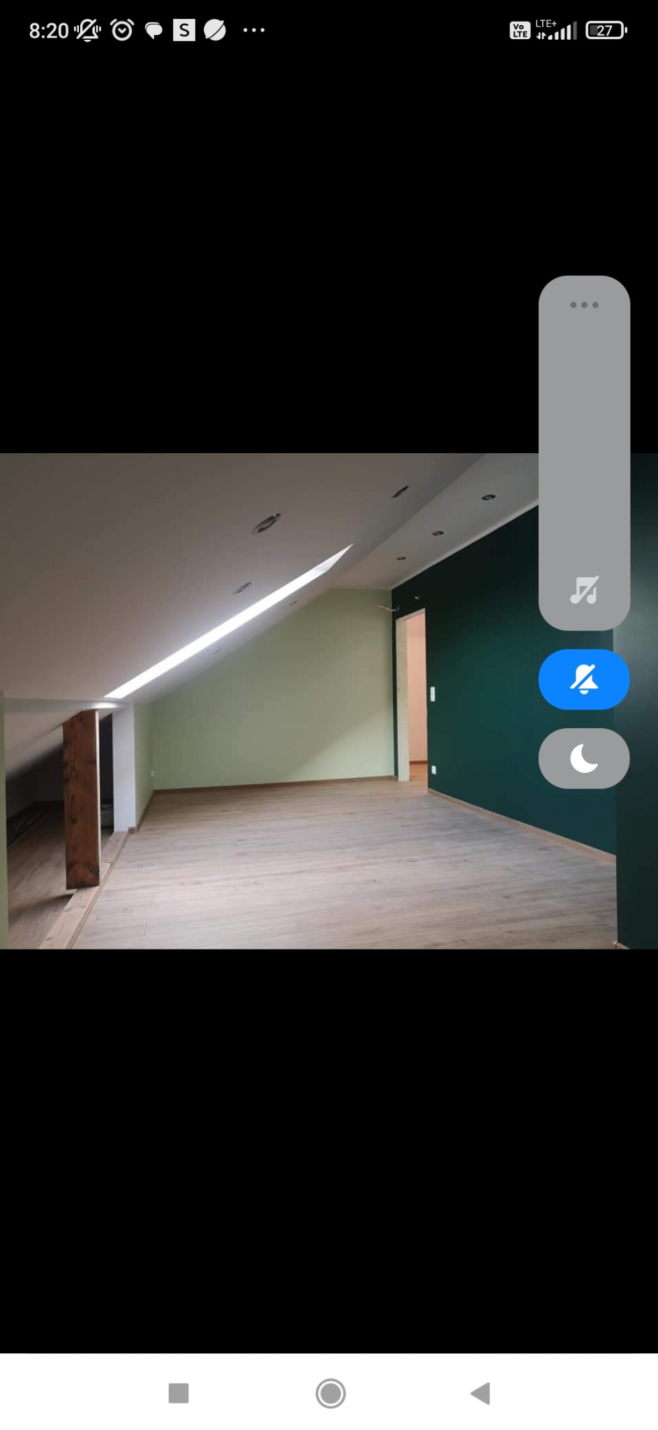 Poddasze po remoncie: drewniana podłoga panelowa, ściany pomalowane na zielono, widoczne drewniane elementy konstrukcyjne i skos dachu z oknem.