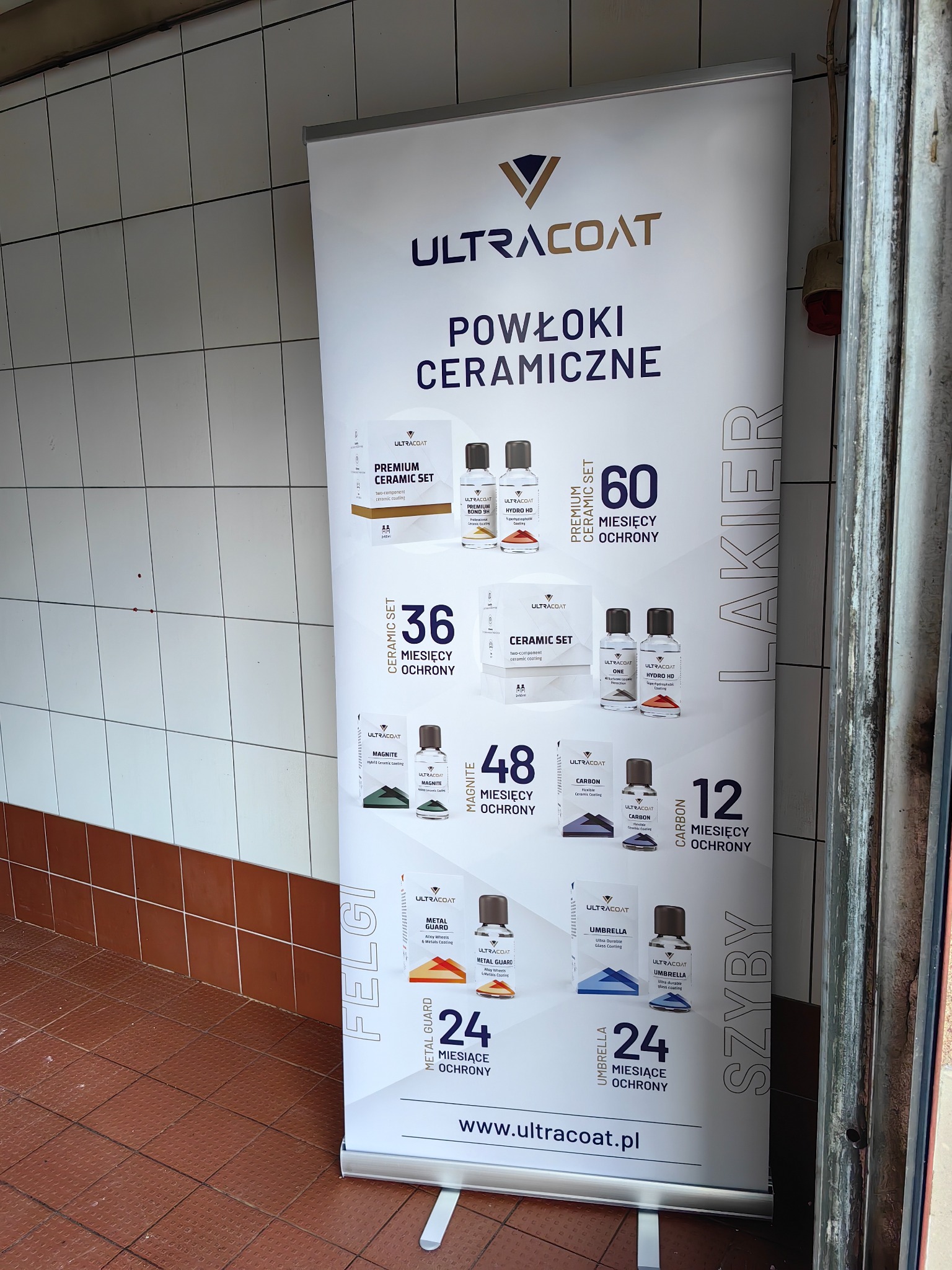 Roll-up reklamowy z powłokami ceramicznymi Ultracoat, prezentujący różne zestawy produktów do ochrony lakieru, felg i szyb, z informacją o długotrwałej ochronie w miesiącach.