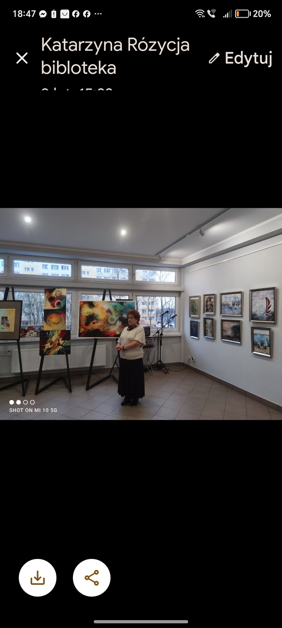 Wystawa obrazów w galerii: kobieta prezentuje abstrakcyjne obrazy na sztalugach, w tle pejzaże na ścianie.