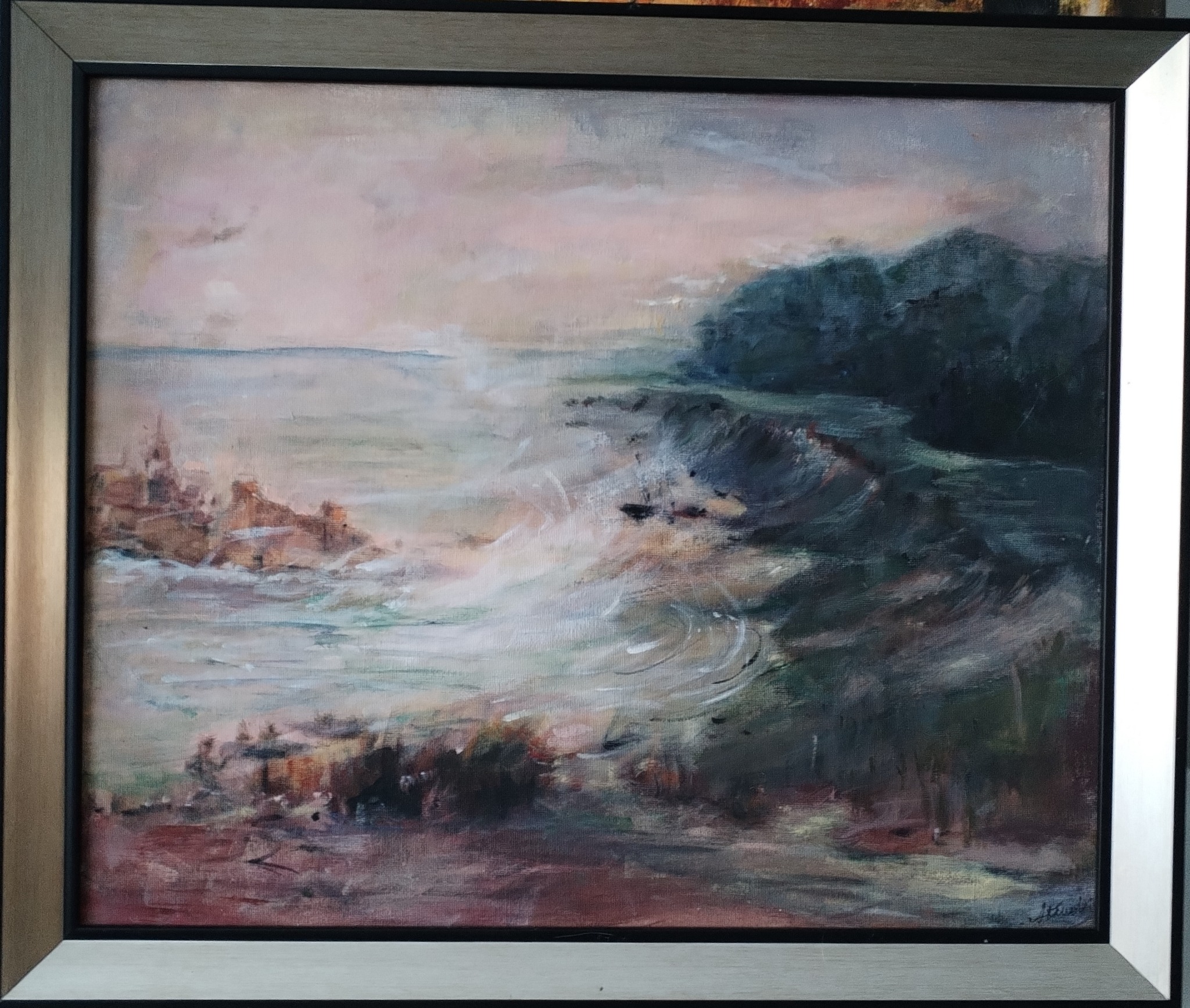 Pejzaż morski z falami rozbijającymi się o skały, namalowany farbami olejnymi i oprawiony w srebrną ramę.