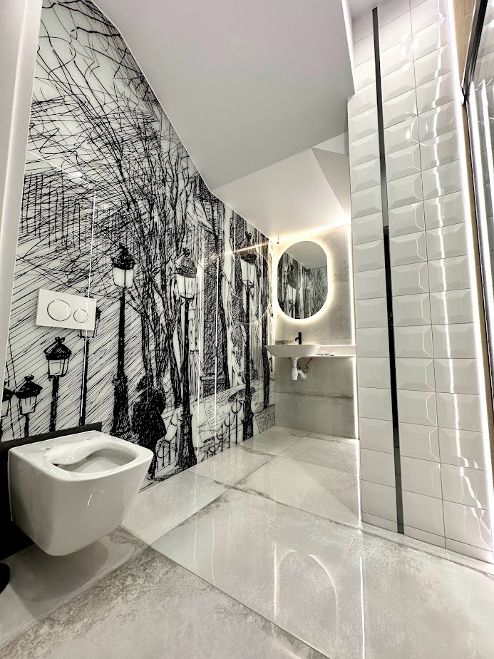 Nowoczesna łazienka z toaletą podwieszaną na tle ściany z grafiką paryskiej ulicy, podświetlane lustro owalne i białe płytki strukturalne.