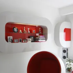 Nowoczesna, biała półka ścienna z czerwonym wnętrzem, eksponująca dekoracje, zdjęcia w ramkach i książki, obok okno z szarą roletą rzymską i biała kolumna głośnikowa, w dole widoczny fragment...