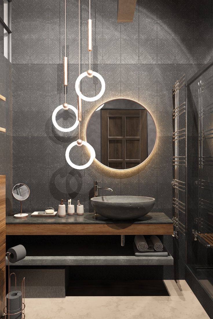 Nowoczesna łazienka z umywalką w kształcie misy, podświetlanym okrągłym lustrem i wiszącymi lampami z okrągłymi elementami, na tle ciemnoszarych płytek z subtelnym wzorem jodełki.