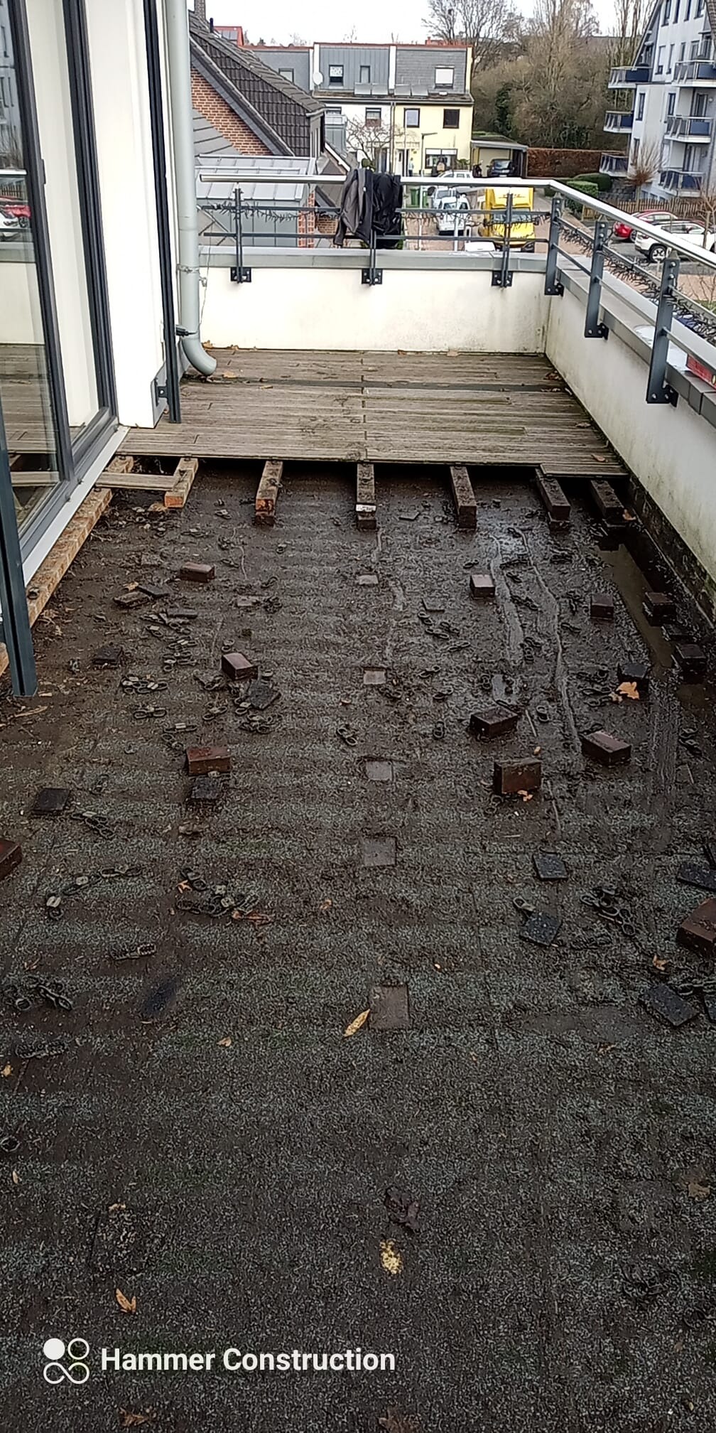 Demontaż starej podłogi na balkonie, widoczne legary i pozostałości po kostce brukowej, przygotowanie do nowej nawierzchni.