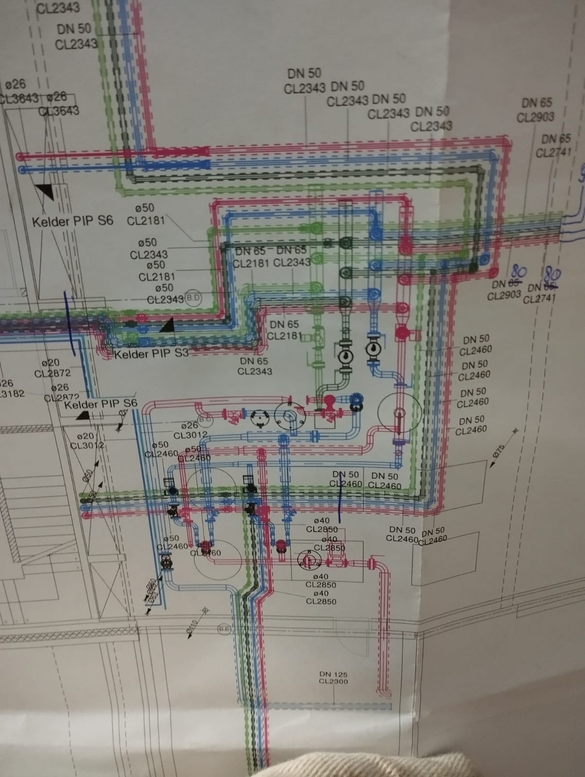 Schemat instalacji wodno-kanalizacyjnej na planie budynku, z kolorowymi liniami oznaczającymi rury i złączki, z naniesionymi oznaczeniami średnic i numerów katalogowych elementów.
