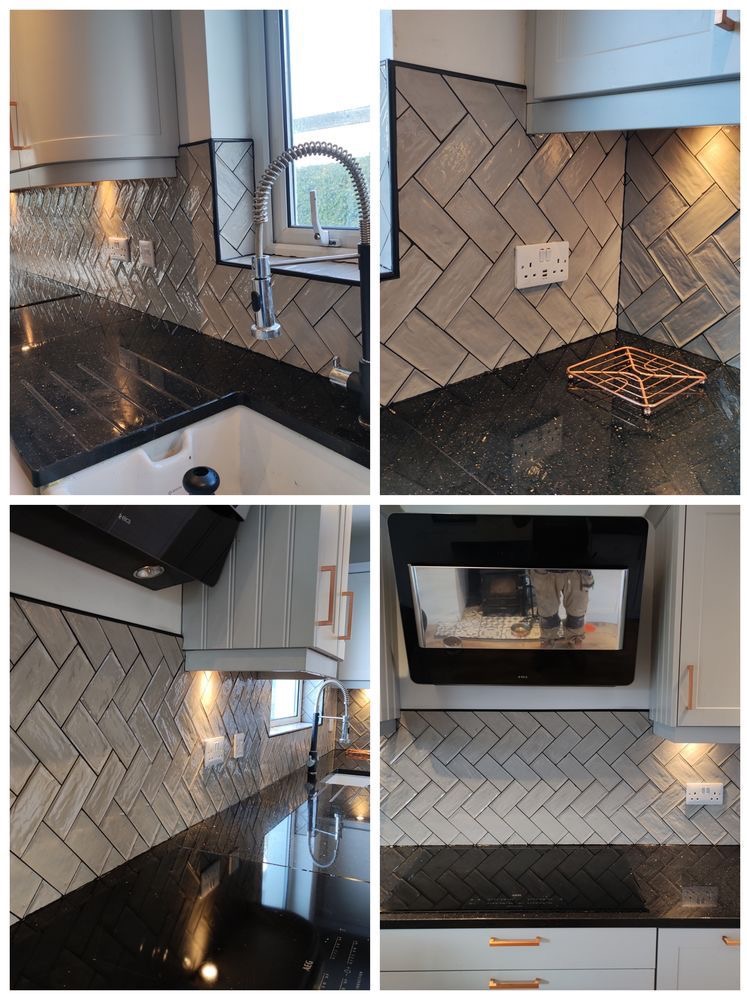 Wykończona kuchnia z szarymi płytkami ułożonymi w jodełkę na ścianie nad czarnym, błyszczącym blatem, widoczny zlew, bateria i okap.