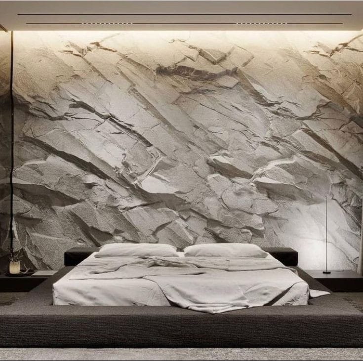 Sypialnia z łóżkiem na podwyższeniu i ścianą imitującą skalną formację podświetloną listwą LED.