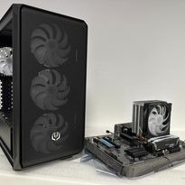 Otwarta obudowa komputera PC z trzema wentylatorami z przodu, obok płyta główna z zamontowanym chłodzeniem procesora na białym tle.