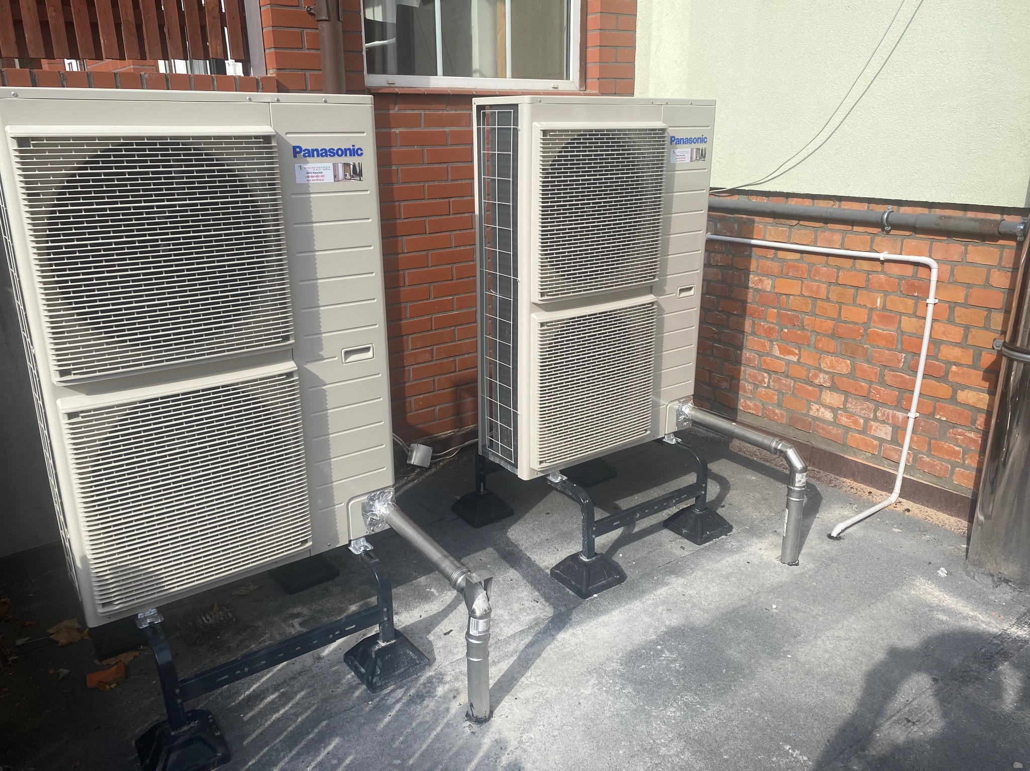 Dwa zewnętrzne moduły klimatyzacji Panasonic zamontowane na dachu, z widocznymi rurami odprowadzającymi skropliny.