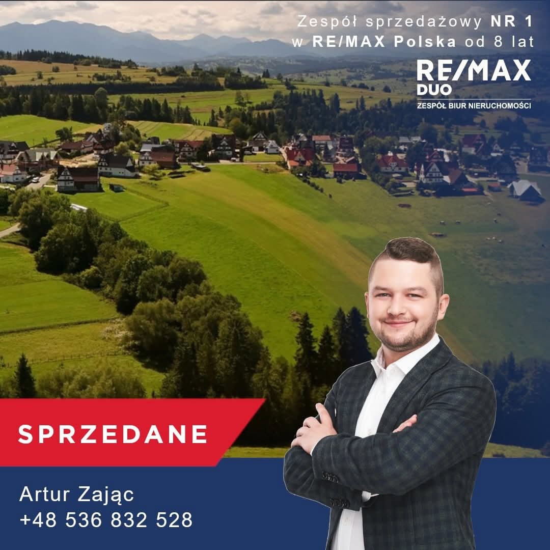 Krajobraz Podhala z agentem nieruchomości RE/MAX, Artur Zając, informujący o sprzedaży działki w Leśnicy. Widok na góry, zieleń i zabudowania.
