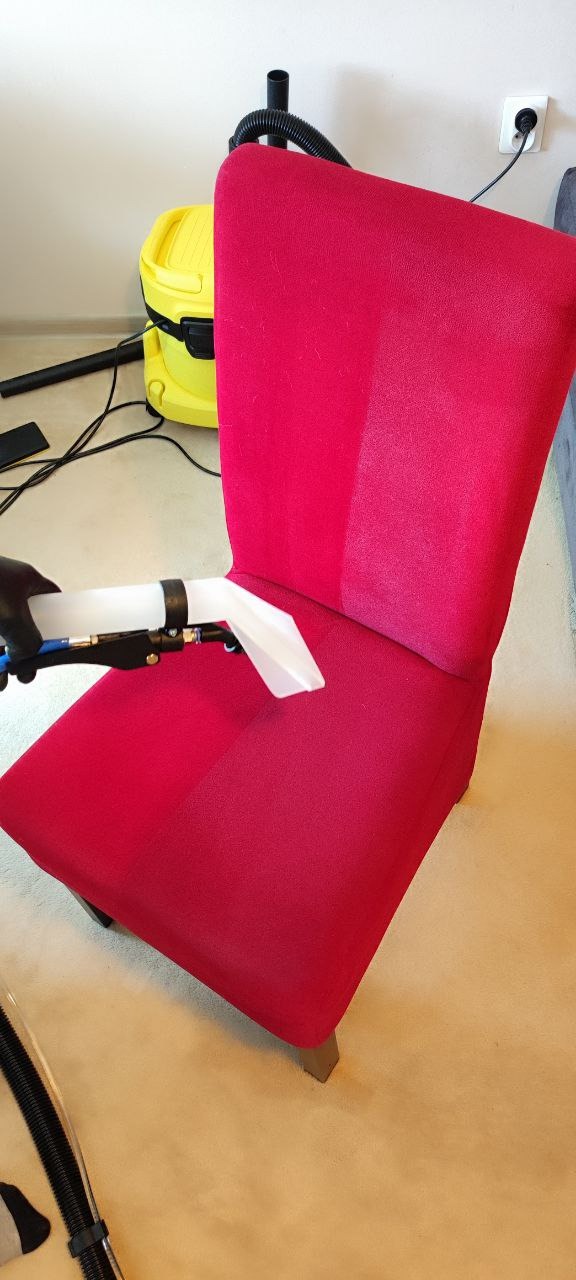 Czerwone krzesło tapicerowane czyszczone parowo-odkurzaczem, widoczna różnica w kolorze po czyszczeniu, żółty odkurzacz w tle.