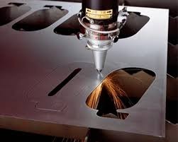 Automat tnący laserem blachę, iskry w wyciętym otworze, precyzyjna obróbka metalu.