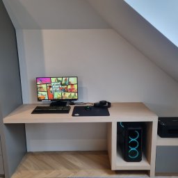 Meble Ledwoń Dawid Ledwoń - Komputer stacjonarny z podświetleniem LED umieszczony w przestrzeni biurka na wymiar, monitor wyświetla grę Grand Theft Auto, obok drukarka, całość w pokoju na poddaszu.