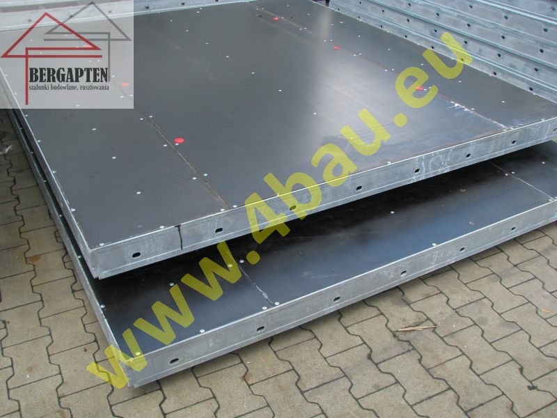 Szalunki budowlane: Dwa panele szalunkowe z czarną powierzchnią i metalową ramą, ułożone jeden na drugim. Widoczne śruby i otwory montażowe.