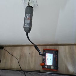 Eco Energo Tech Marcin Litwin - Miernik Sonel WS-03 w gniazdku elektrycznym podczas pomiarów. Widoczny ekran urządzenia z wynikami. Sprzęt do pomiarów elektrycznych w trakcie pracy.