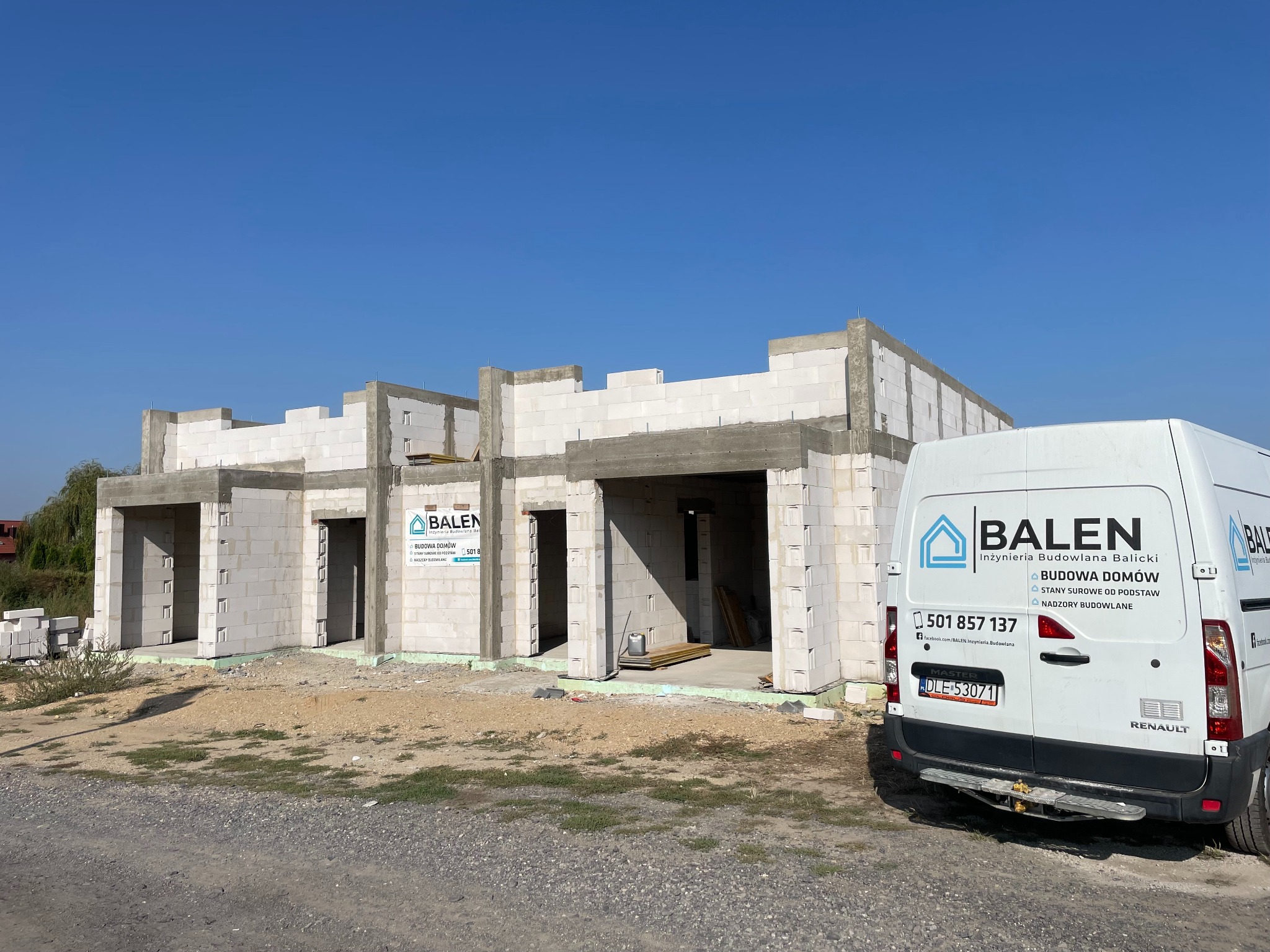 Budowa bliźniaka w stanie surowym otwartym, z widocznym ociepleniem fundamentów i zaparkowanym samochodem firmy budowlanej Balen na pierwszym planie.
