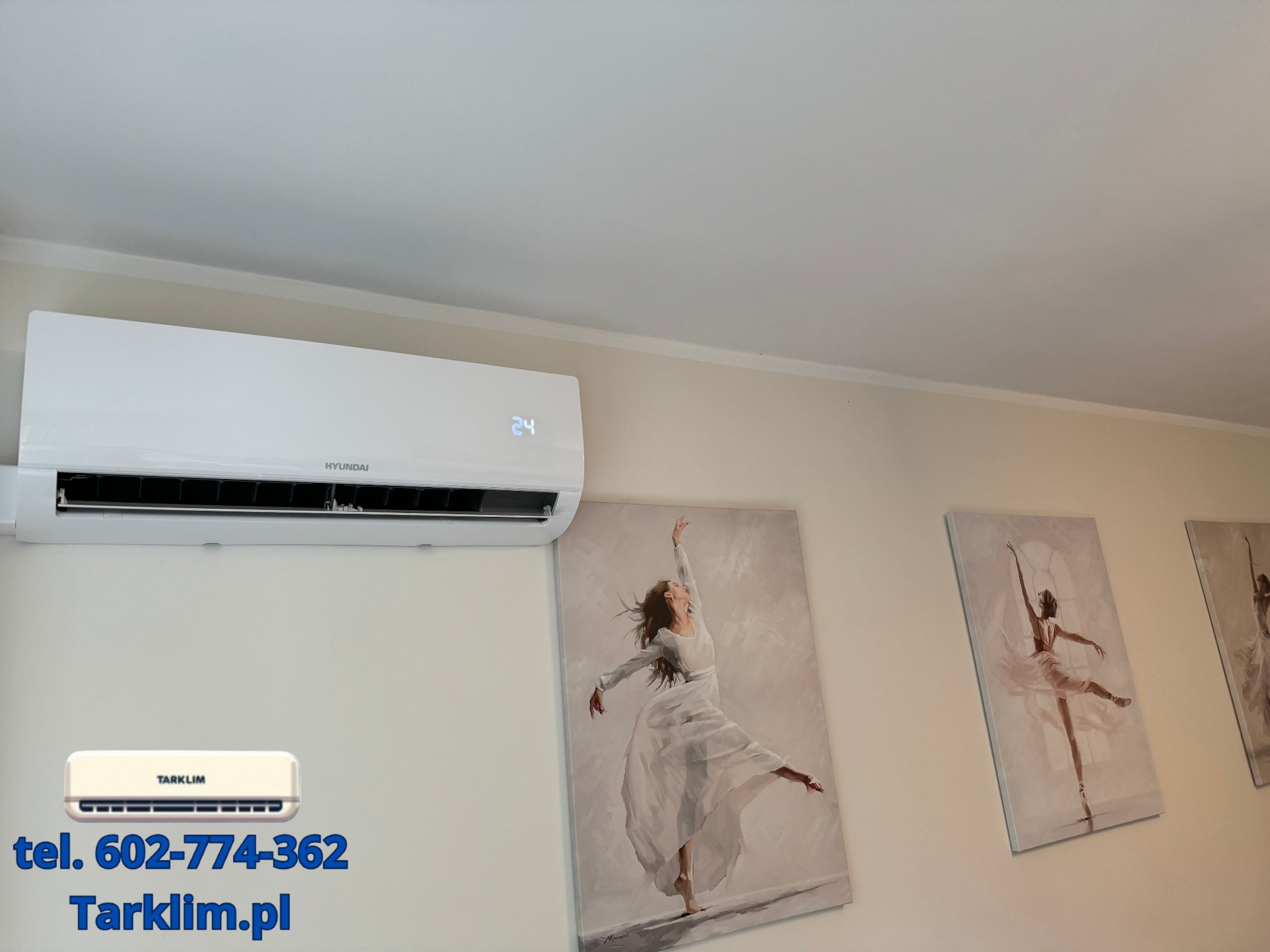Biały klimatyzator Hyundai zamontowany na ścianie nad obrazami baletnic, z widocznym wyświetlaczem temperatury ustawionej na 24 stopnie Celsjusza.
