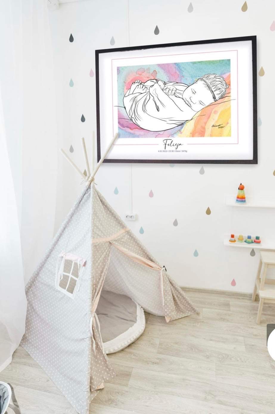 Rysunek śpiącego dziecka w ramce, akwarelowe tło, podpis Felicia, w pokoju dziecięcym z tipi i naklejkami w kształcie kropli.