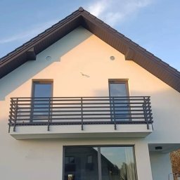 Kam-Weld - Nowoczesna balustrada balkonowa z poziomych profili, zamontowana na jasnej elewacji domu w Tarnowie, widok z dołu.
