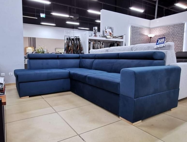 Narożnik tapicerowany w odcieniach granatu z regulowanymi zagłówkami, ekspozycja w salonie meblowym.