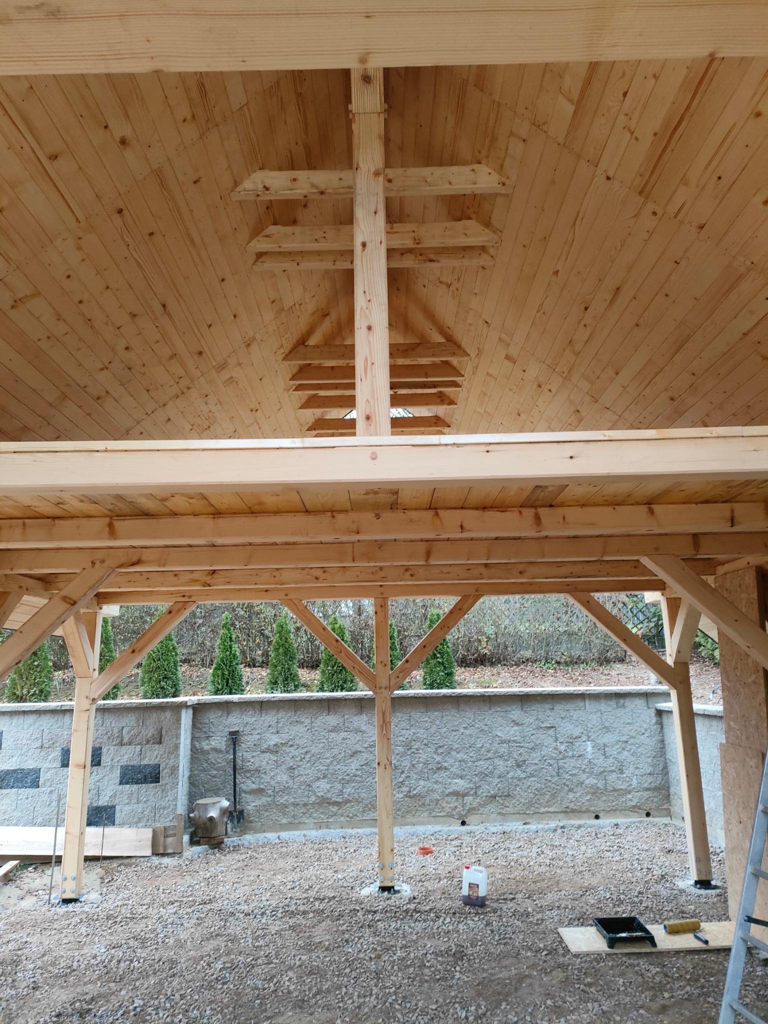 Konstrukcja z surowego drewna w Limanowej, prawdopodobnie altana lub wiata, w trakcie budowy. Widoczne elementy mocujące i narzędzia.