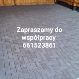 Marcin Stępień - Ułożona szara kostka brukowa w jodełkę na podwórku z drewnianym ogrodzeniem. Na kostce widnieje napis zapraszający do współpracy i numer telefonu.