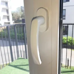 Zamknięte białe okno PCV z widokiem na balkon i budynek mieszkalny w Zgierzu.