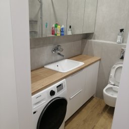 Meble Andrii Pavlenko - Nowoczesna łazienka z drewnianym blatem, białą umywalką, pralką Samsung i szafką z lustrem, minimalistyczny design.