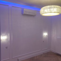 Likes Bud Andrii Fomich - Eleganckie wnętrze z białymi ścianami zdobionymi sztukaterią, parkietem w jodełkę, klimatyzacją, oświetleniem LED i kryształowym żyrandolem.