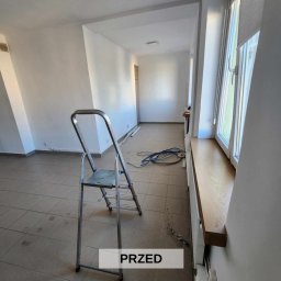 VISARC - Usługi Malarskie - Arkadiusz Wisła - Wnętrze pokoju w trakcie przygotowań do remontu: białe ściany, aluminiowa drabina, przewody elektryczne na podłodze, widoczny napis 'PRZED'.