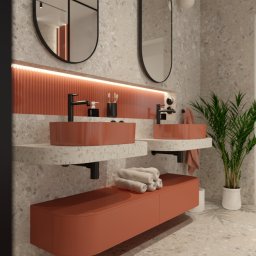 Jakub Pastuszka Kontur Wnętrz - Nowoczesna łazienka z dwoma umywalkami w kolorze terakoty, armaturą w kolorze czarnym, lustrami owalnymi z czarną ramą, blatem z lastryko i rośliną doniczkową.