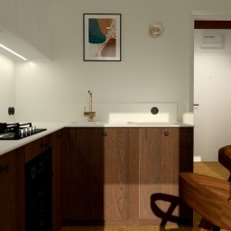 Jakub Pastuszka Kontur Wnętrz - Wizualizacja kuchni z drewnianymi szafkami, złotą armaturą i płytą indukcyjną w minimalistycznym stylu, z drewnianym stołem i krzesłami w tle.