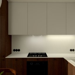 Jakub Pastuszka Kontur Wnętrz - Wizualizacja kuchni z drewnianymi szafkami dolnymi i białymi górnymi, złota bateria przy białym zlewie, płyta indukcyjna i piekarnik w zabudowie, minimalistyczny obraz na ścianie.