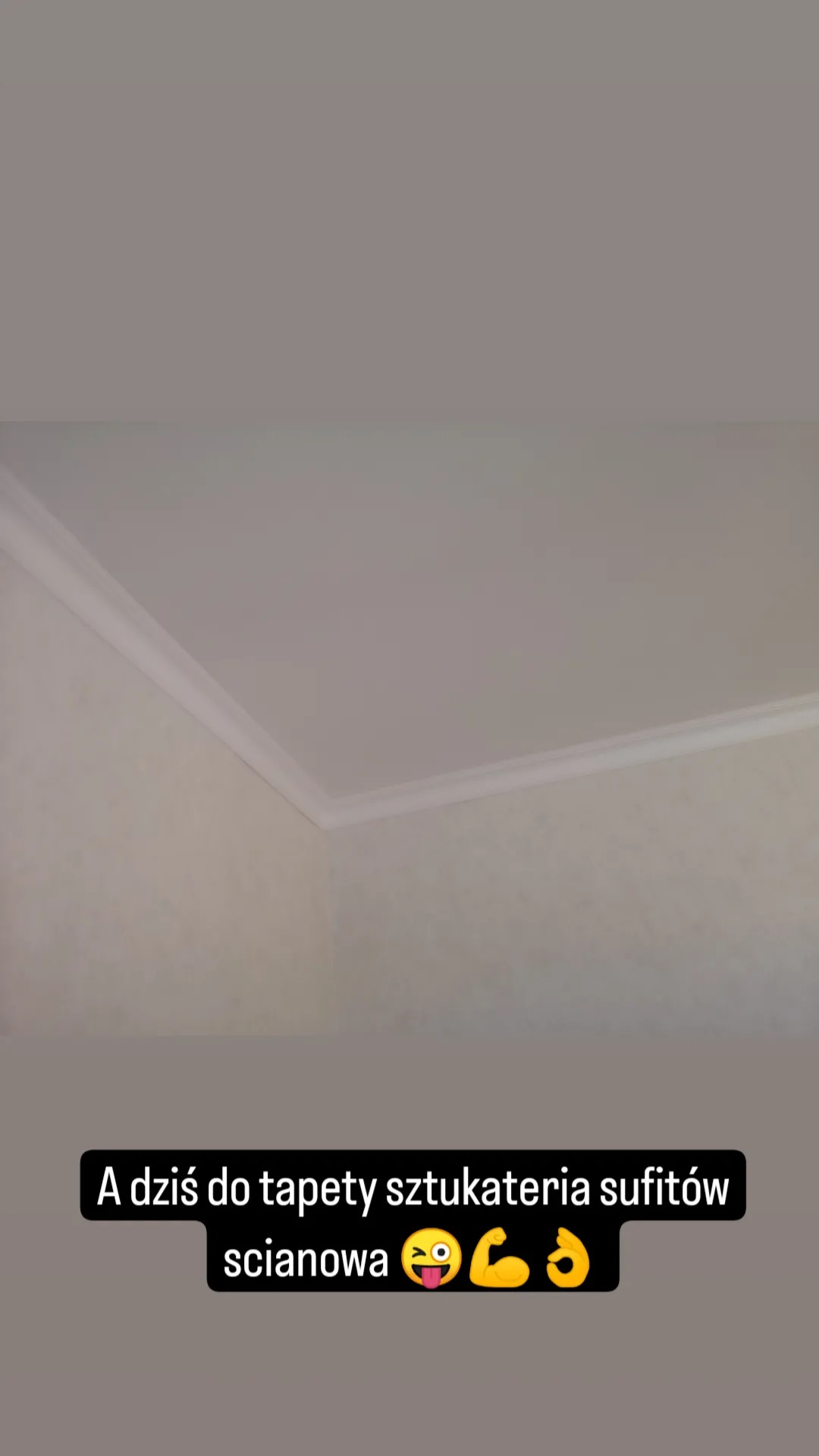 Wykończony narożnik pokoju z zamontowaną, białą listwą dekoracyjną na styku ściany i sufitu. Ściana ma jasny, delikatny wzór.