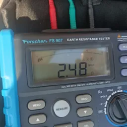 Miernik rezystancji uziemienia Forscher FS 907 z wyświetlonym wynikiem 2.48 omów, ustawiony na tryb 3-polowy, z podłączonymi przewodami pomiarowymi w kolorach czerwonym, zielonym i czarnym.