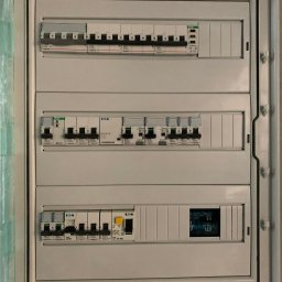 Instalacje elektryczne Krzysztof Niemiec - Rozdzielnica elektryczna z bezpiecznikami Legrand i EATON, widok z bliska na zamontowane zabezpieczenia w skrzynce elektrycznej w kolorze białym.