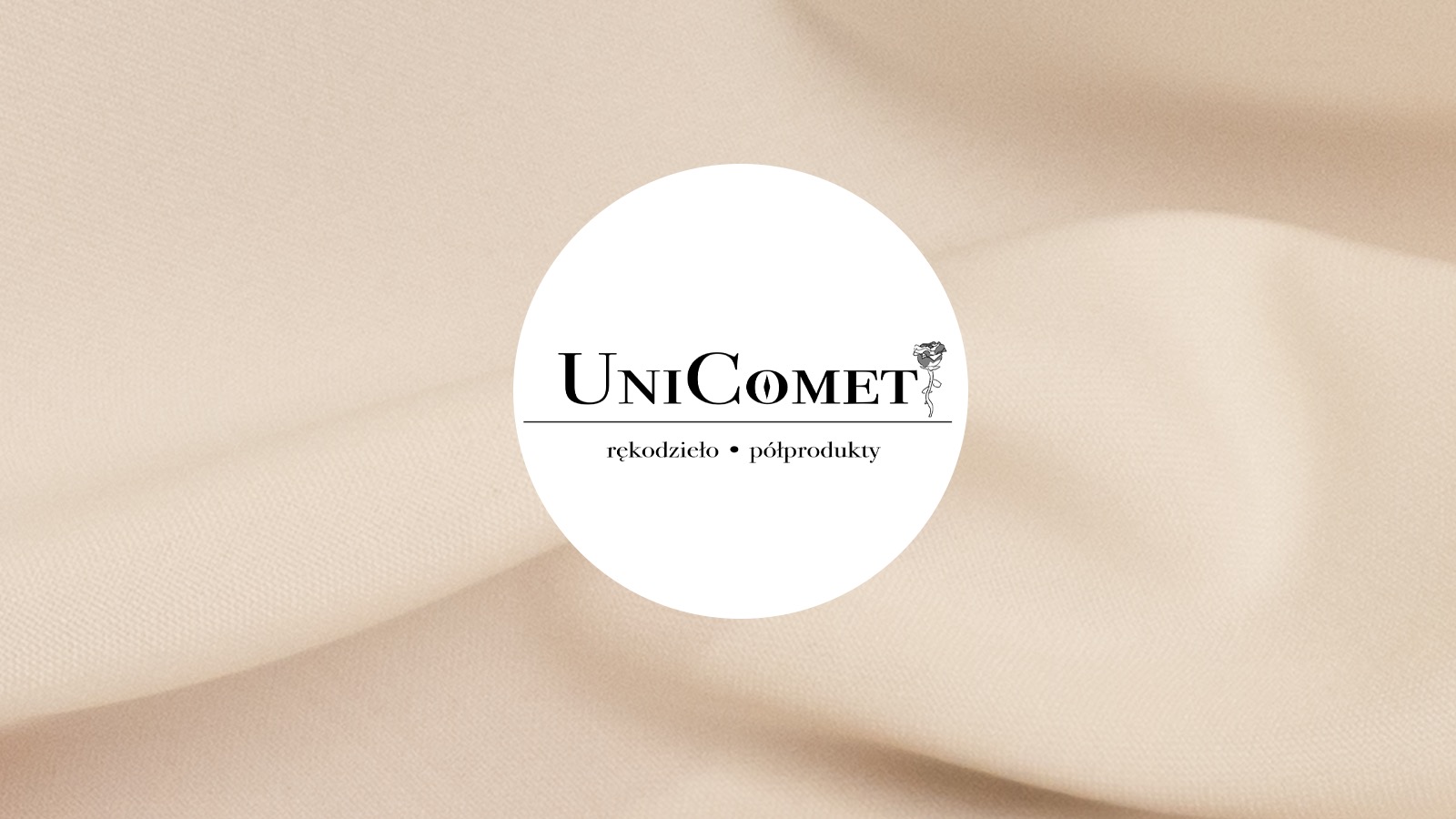 Minimalistyczne logo Unicomet z motywem róży, umieszczone na beżowym, delikatnie pofałdowanym tle materiału.